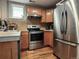 Well-lit kitchen featuring stainless steel appliances, wood cabinets, and a window for natural light at 1580 N Franklin St, Denver, CO 80218