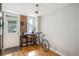 Cozy living room featuring wooden floorboards, exposed brick, and a desk with a window view at 1580 N Franklin St, Denver, CO 80218