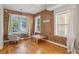 Bright living room featuring hardwood floors, exposed brick wall, and multiple windows at 1580 N Franklin St, Denver, CO 80218