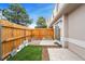 Backyard patio features a wooden fence, artificial turf, and a sliding glass door at 7999 Chase Cir # 31, Arvada, CO 80003