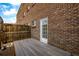 Backyard with a brick building, fenced-in area, wooden deck, and exterior door at 70 N Grant St # 10, Denver, CO 80203