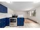 Modern kitchen with stainless steel appliances, navy cabinets, and bright adjoining living space at 70 N Grant St # 10, Denver, CO 80203