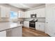 Bright kitchen featuring white cabinetry, stainless steel appliances, and a breakfast bar at 48270 Shetland Dr, Bennett, CO 80102