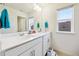 Bright bathroom with double vanity, window, and tile flooring, designed with white cabinets and a clean aesthetic at 14696 Bonsmara Dr, Mead, CO 80542