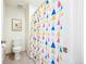 Compact bathroom featuring a toilet and a colorful, patterned shower curtain adding a splash of character to the space at 14696 Bonsmara Dr, Mead, CO 80542