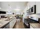 Well-lit kitchen featuring modern appliances, a dual sink, and an open layout with the living room visible at 14696 Bonsmara Dr, Mead, CO 80542