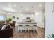 Open kitchen with white cabinets, stainless appliances, island with seating, and adjacent dining area at 14696 Bonsmara Dr, Mead, CO 80542