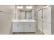 Bathroom featuring a double sink vanity with a large mirror and a glass-enclosed shower at 18358 Field Mint Pt, Parker, CO 80134