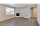 Bright living room with fireplace and vinyl flooring, filled with natural light from a large window at 18358 Field Mint Pt, Parker, CO 80134