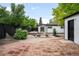 Spacious backyard featuring a brick patio, gravel, landscaping and detached garage at 1264 Uinta St, Denver, CO 80220
