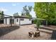 Spacious backyard featuring a brick patio, gravel, landscaping and detached garage at 1264 Uinta St, Denver, CO 80220