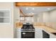 Kitchen featuring stainless steel appliances, stone countertops, and exposed beams at 1264 Uinta St, Denver, CO 80220