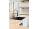 The kitchen sink has matte black hardware with stainless steel appliances, stone countertops, and open shelving at 1264 Uinta St, Denver, CO 80220