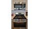 New stainless steel oven and microwave with gray backsplash and cabinets at 1295 Utica St, Denver, CO 80204