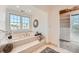 Inviting bathroom features a soaking tub, large window, and an organized walk-in closet at 19 Red Fox Ln, Littleton, CO 80127