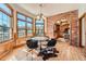 Dining area with brick accent wall, large windows, hardwood floors, and decorative rug at 19 Red Fox Ln, Littleton, CO 80127