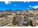 Picturesque exterior view of a charming home with a covered porch, set against a backdrop of rolling hills and blue skies at 19 Red Fox Ln, Littleton, CO 80127