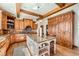 Bright kitchen with wooden cabinets, center island, granite counters, hardwood floors, and beam ceiling at 19 Red Fox Ln, Littleton, CO 80127