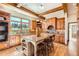 Kitchen with wooden cabinets, granite counters, center island, hardwood floors, beam ceiling, and window at 19 Red Fox Ln, Littleton, CO 80127