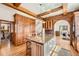 Gourmet kitchen featuring custom wood cabinets, a brick archway and hardwood floors at 19 Red Fox Ln, Littleton, CO 80127