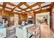 Living room showcasing hardwood floors, coffered ceiling, brick fireplace, and open layout at 19 Red Fox Ln, Littleton, CO 80127