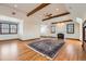 Spacious living room featuring wood beams, a fireplace, and hardwood floors at 19 Red Fox Ln, Littleton, CO 80127