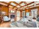 Living room features wood-paneled walls, beamed ceiling, fireplace, and hardwood floors at 19 Red Fox Ln, Littleton, CO 80127