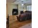 Living room with hardwood floors, fireplace, and brown leather couches at 13349 Krameria St, Thornton, CO 80602