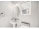 Well-lit half bath featuring a pedestal sink, oval mirror, and neutral tones at 20558 E Grand Ln, Aurora, CO 80015