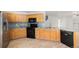 Well-equipped kitchen featuring wood cabinetry, granite countertops, and black appliances at 20558 E Grand Ln, Aurora, CO 80015