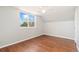 Comfortable bedroom featuring wood floors, a ceiling fan, neutral walls, and natural light from the large window at 3270 W 92Nd Pl, Westminster, CO 80031