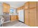 Bright kitchen featuring wood cabinets, white subway tile backsplash, laminate floors, and stainless steel appliances at 3270 W 92Nd Pl, Westminster, CO 80031