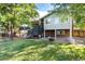Spacious backyard featuring a well-maintained lawn, a fire pit, and an elevated deck with stairs leading down to the yard at 8063 S Otis Ct, Littleton, CO 80128