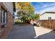 Backyard patio featuring a brick house exterior, grill and a beautiful shade tree in a fenced backyard at 8063 S Otis Ct, Littleton, CO 80128