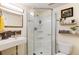 Bright bathroom featuring a glass door shower, floating shelves, and a sink with modern fixtures creating a clean aesthetic at 8063 S Otis Ct, Littleton, CO 80128