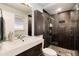 Modern bathroom featuring a sleek sink, tiled shower with glass door, and contemporary fixtures for a spa-like feel at 8063 S Otis Ct, Littleton, CO 80128