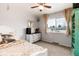 Comfortable bedroom with carpet, window views, and stylish decor including a dresser and unique wall art at 8063 S Otis Ct, Littleton, CO 80128