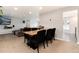 Open dining room with wooden table, six chairs, adjacent to living room with gray sectional couch at 8063 S Otis Ct, Littleton, CO 80128