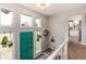 Bright foyer with a modern staircase, unique turquoise door, and views into the adjacent kitchen at 8063 S Otis Ct, Littleton, CO 80128