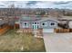 Two-story home with gray siding, brick accents, and a two-car garage, complemented by solar panels at 8063 S Otis Ct, Littleton, CO 80128