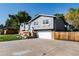 Well-maintained two-story home with gray siding, brick accents, a two-car garage, and a spacious driveway at 8063 S Otis Ct, Littleton, CO 80128