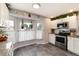 Updated kitchen featuring white cabinets, stainless steel appliances, granite countertops, and natural light at 8063 S Otis Ct, Littleton, CO 80128