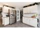 Modern kitchen featuring white cabinets, stainless steel refrigerator, and stylish tile flooring at 8063 S Otis Ct, Littleton, CO 80128