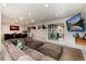 Open living room with a gray sectional couch, adjacent to the dining area and outdoor porch at 8063 S Otis Ct, Littleton, CO 80128