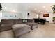 Spacious living room with a comfortable sofa, a large window, and direct access to the dining area at 8063 S Otis Ct, Littleton, CO 80128