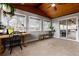 Inviting sunroom featuring a wood ceiling, carpet flooring, desk area, and access to an outdoor porch at 8063 S Otis Ct, Littleton, CO 80128