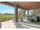 Covered back porch with stone pillars, hot tub, and staircase to the yard at 8691 S Sicily Ct, Aurora, CO 80016