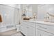 Bright bathroom featuring a tub, shower, white cabinets, and quartz countertops at 8691 S Sicily Ct, Aurora, CO 80016
