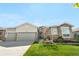 Attractive home with stone and siding exterior, three-car garage, and beautifully landscaped front yard at 8691 S Sicily Ct, Aurora, CO 80016