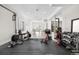 Home gym with various exercise machines, weights, and adjacent entertainment area with ping pong table at 8691 S Sicily Ct, Aurora, CO 80016